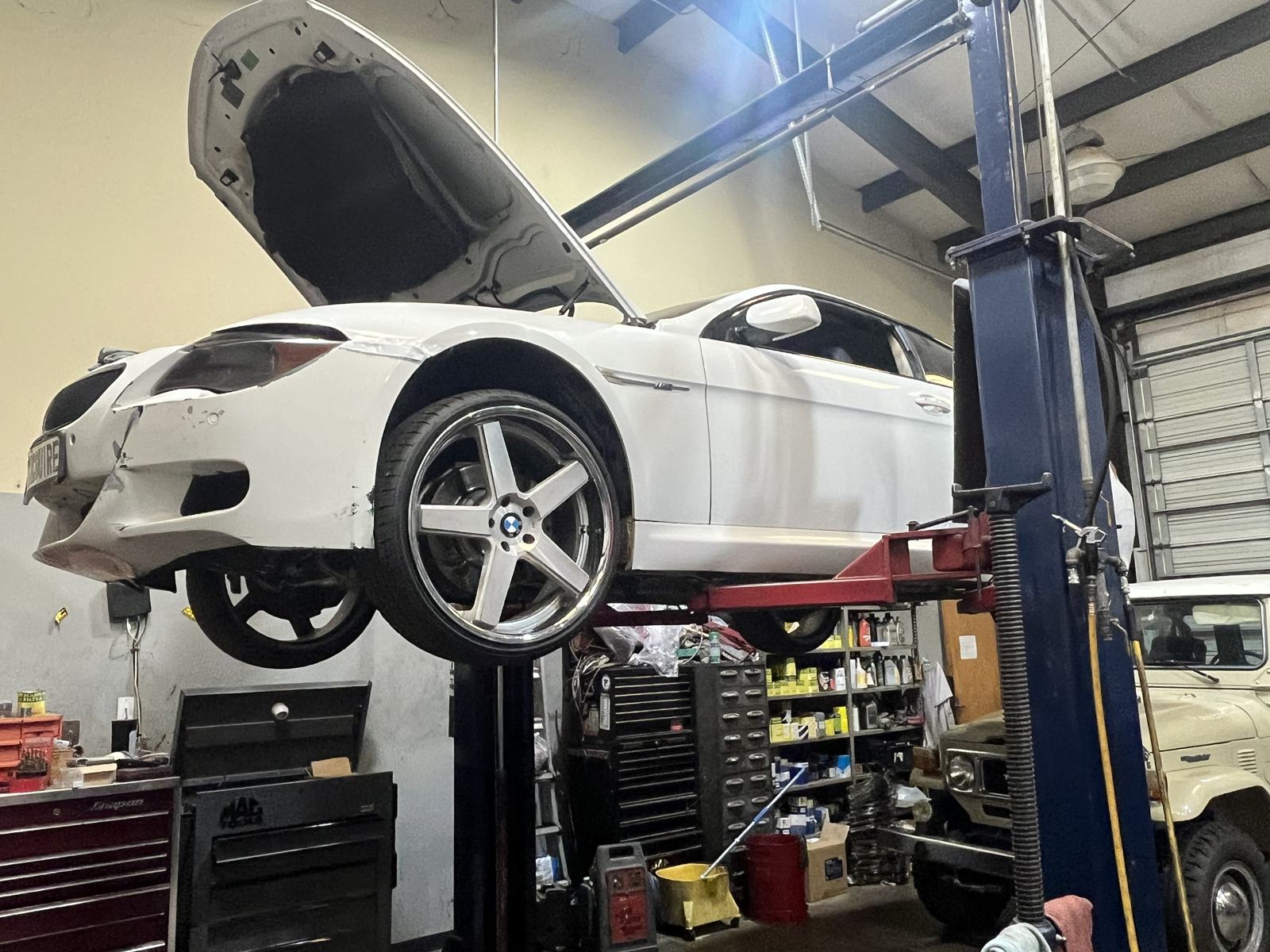 BMW coupe on a lift for brake and suspension service in Athens