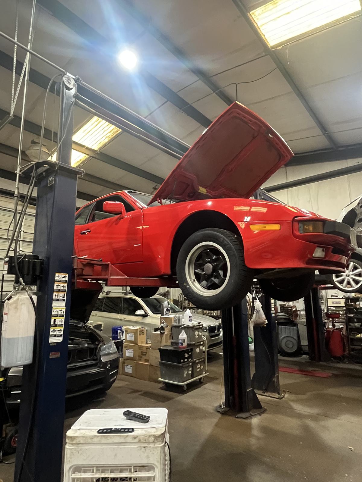 Classic red Porsche 944 on a lift at Athens Import Auto Repair