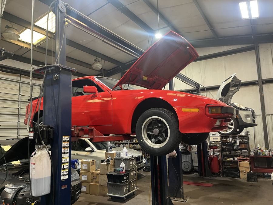 Porsche 944 with the engine bay open on a lift in Athens, GA