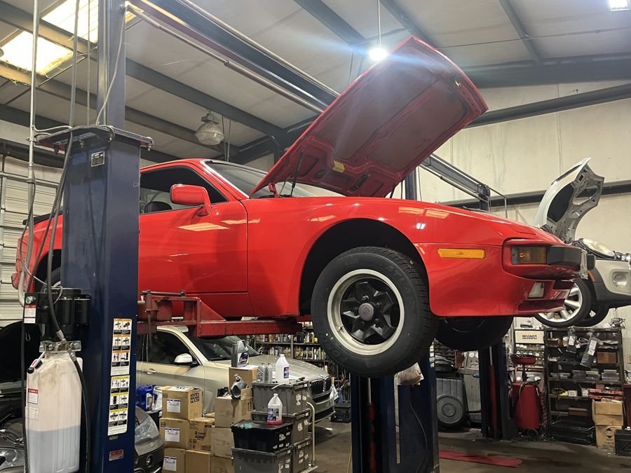Red Porsche 944 on a two post lift at Athens Import Auto Repair